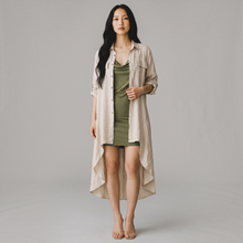 Load image into Gallery viewer, Model wearing Aurora Boutique Miami beige linen high-low cover up with collar and mock pockets over a green dress