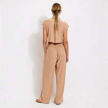 Load image into Gallery viewer, Model wearing Aurora Boutique Miami beige ribbed jumpsuit with collar and cut out back detail, back view