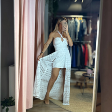 Load image into Gallery viewer, Aurora Boutique Miami white Carla romper dress with a halter neckline and sheer lace overlay in a boutique setting.
