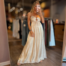 Load image into Gallery viewer, Aurora Boutique Miami Anori maxi dress in champagne satin with open bust, tie back, and spaghetti straps on a model

