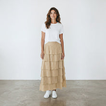 Load image into Gallery viewer, Model wearing an Aurora Boutique Miami beige tiered cotton maxi skirt with a white t-shirt and sneakers
