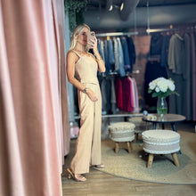 Load image into Gallery viewer, Model wearing a beige Aurora Boutique Miami Lucy viscose jumpsuit with a square neckline in a boutique setting
