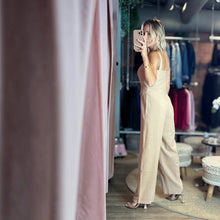Load image into Gallery viewer, Model wearing a beige Aurora Boutique Miami Lucy viscose jumpsuit with wide legs in a boutique setting
