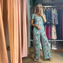 Load image into Gallery viewer, Aurora Boutique Miami Cite floral jumpsuit with green palm leaf print on a light purple background and flutter sleeves

