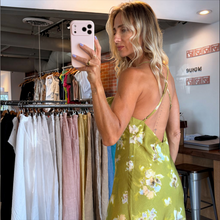 Load image into Gallery viewer, Aurora Boutique Miami floral cowl neck midi slip dress with thin adjustable straps worn by a blonde model in a store
