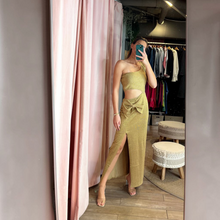 Load image into Gallery viewer, Aurora Boutique Miami gold lurex crochet one-shoulder cutout maxi dress with a side slit worn by a model in a mirror
