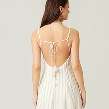 Load image into Gallery viewer, Model wearing Aurora Boutique Miami Ivetta open back midi dress with thin straps, tassel ties, and button details.
