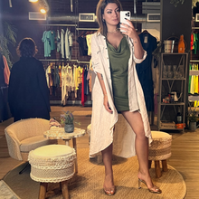 Load image into Gallery viewer, Aurora Boutique Miami Leslie high low linen cover up in beige worn by a model in a boutique setting
