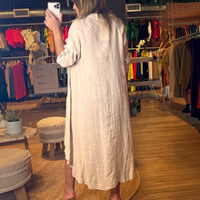 Load image into Gallery viewer, Aurora Boutique Miami Leslie high low linen cover up in beige with a fishtail hem and collar, worn by a model.
