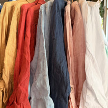 Load image into Gallery viewer, Aurora Boutique Miami Luna linen shirt dresses in a variety of vibrant colours hanging on a clothing rack
