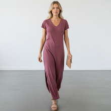 Load image into Gallery viewer, Model wearing an Aurora Boutique Miami mauve cotton t-shirt dress with a v-neck and side slit in a studio setting.
