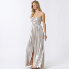 Load image into Gallery viewer, Model wearing Aurora Boutique Miami Fortul metallic silver strapless maxi dress with a twist front bust and side slit

