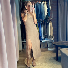 Load image into Gallery viewer, A woman wearing an Aurora Boutique Miami nude knit midi dress with a textured wave pattern and a high side slit.
