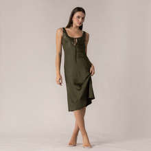 Load image into Gallery viewer, Model wearing an Aurora Boutique Miami olive green satin midi dress with a scoop neckline and front tie detail
