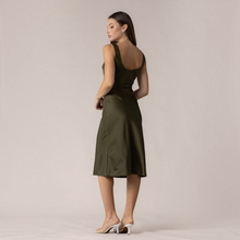 Load image into Gallery viewer, Model wearing Aurora Boutique Miami olive green satin midi dress with a scoop back, viewed from the side
