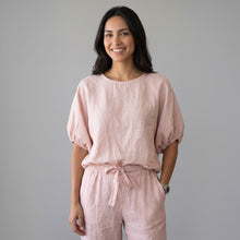 Load image into Gallery viewer, Model wearing Aurora Boutique Miami Delmar linen blouse in soft pink with puff sleeves against a grey background
