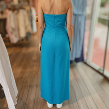 Load image into Gallery viewer, Back view of a model wearing the Aurora Boutique Miami Raleigh strapless blue midi dress in a clothing store
