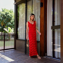Load image into Gallery viewer, Model wearing a vibrant red Aurora Boutique Miami Valentina crochet maxi dress with a scoop neckline on a patio.
