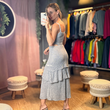 Load image into Gallery viewer, Model wearing Aurora Boutique Miami silver lurex crochet midi dress with tiered ruffle skirt in a boutique setting
