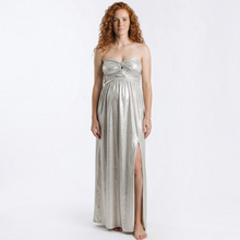 Load image into Gallery viewer, Model wearing a metallic silver Aurora Boutique Miami Fortul maxi dress with a twist front bust and side slit
