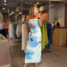 Load image into Gallery viewer, Aurora Boutique Miami Caceres strapless maxi dress with blue floral print and back chest tie in a boutique setting
