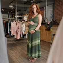 Load image into Gallery viewer, Aurora Boutique Miami Sueli crochet dress in green ombré gradient stripes worn by a pregnant woman in a boutique.
