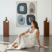 Load image into Gallery viewer, Model wearing an Aurora Boutique Miami white Suzanne skirt set with a vest top, sitting on a gallery floor.
