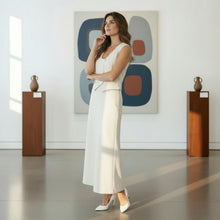 Load image into Gallery viewer, Model wearing a white Aurora Boutique Miami Suzanne Skirt Set in a modern art gallery with white walls and paintings.
