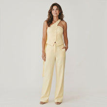 Load image into Gallery viewer, Model wearing Aurora Boutique Miami yellow Miranda pants set with an asymmetrical button-down top and wide-leg trousers
