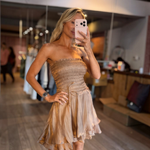 Load image into Gallery viewer, Aurora Boutique Miami Zaragoza mini dress in metallic beige organza with a smocked tube bodice and belted waist
